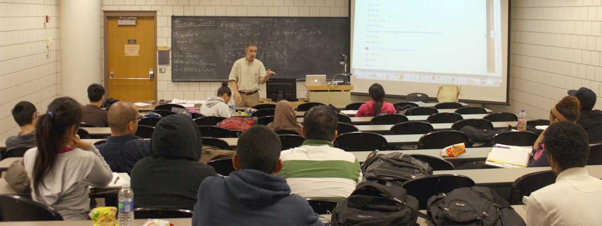 College Readiness at Minneapolis College Instructor standing at the front of a full classrom, talking to the class