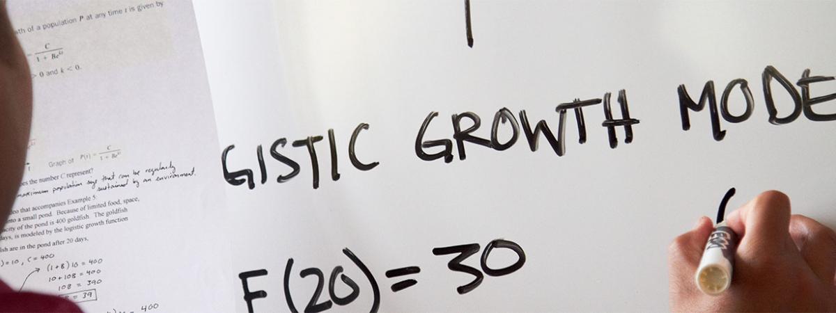 Economics Program at Minneapolis College student writing assignment on a white board