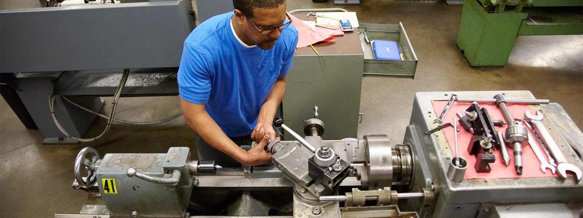 Train For a Career at Minneapolis College Student working a lathe in a machine shop