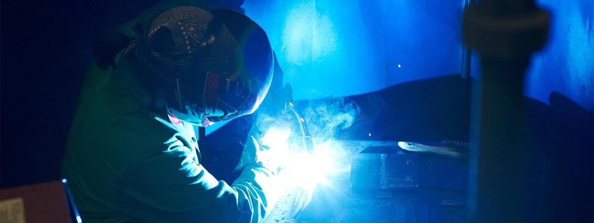 Welding and Metal Fabrication at Minneapolis College Student wearing welding mask performing a welding project