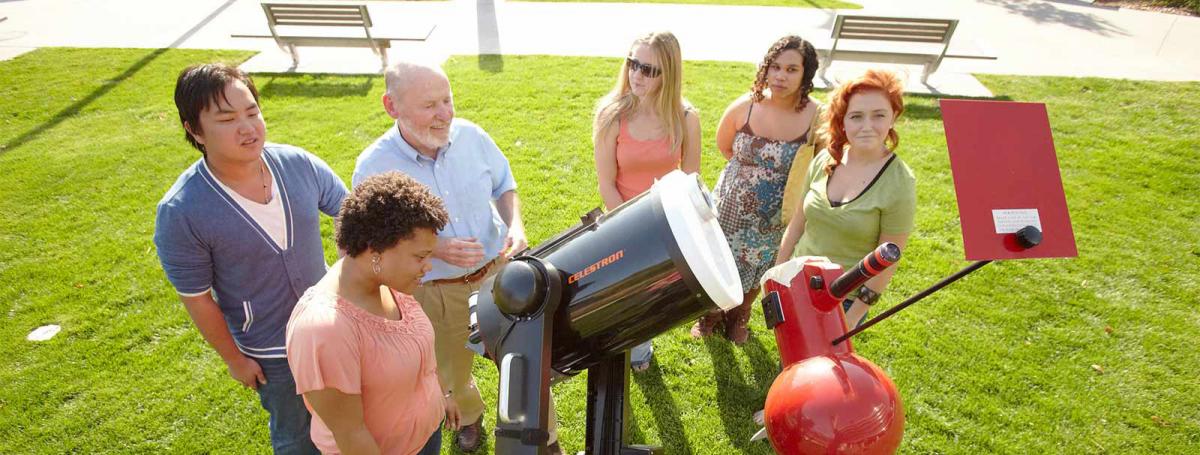 Astronomy Program at Minneapolis College students standing around a telescope with the instructor