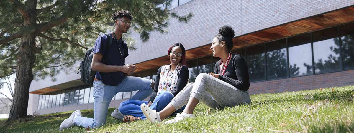 Campus Life at Minneapolis College 3 students on the lawn in front of the Kopp Building at Minneapolis College