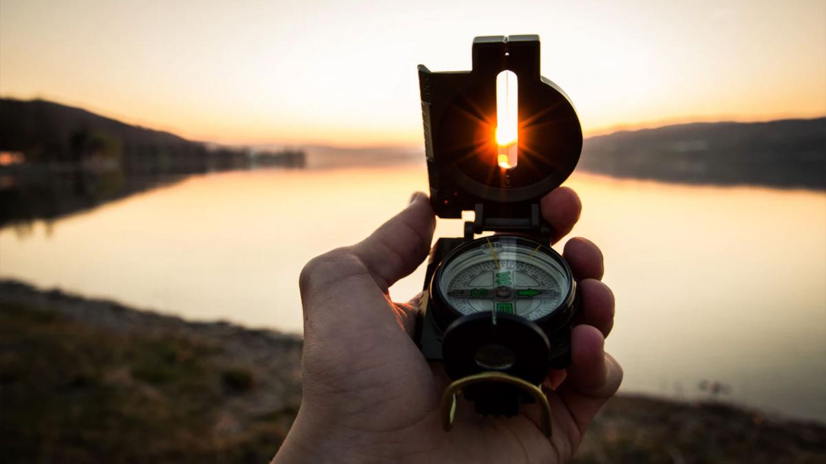 Study Geography at Minneapolis College A compass being held up showing the sun shining through the sighting tab