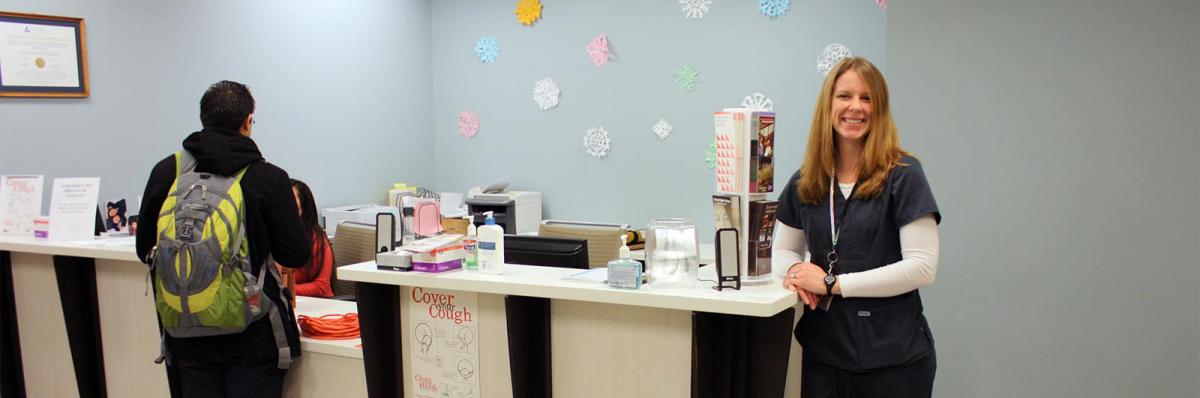 Health Program at Minneapolis College health worker standing at the Health desk