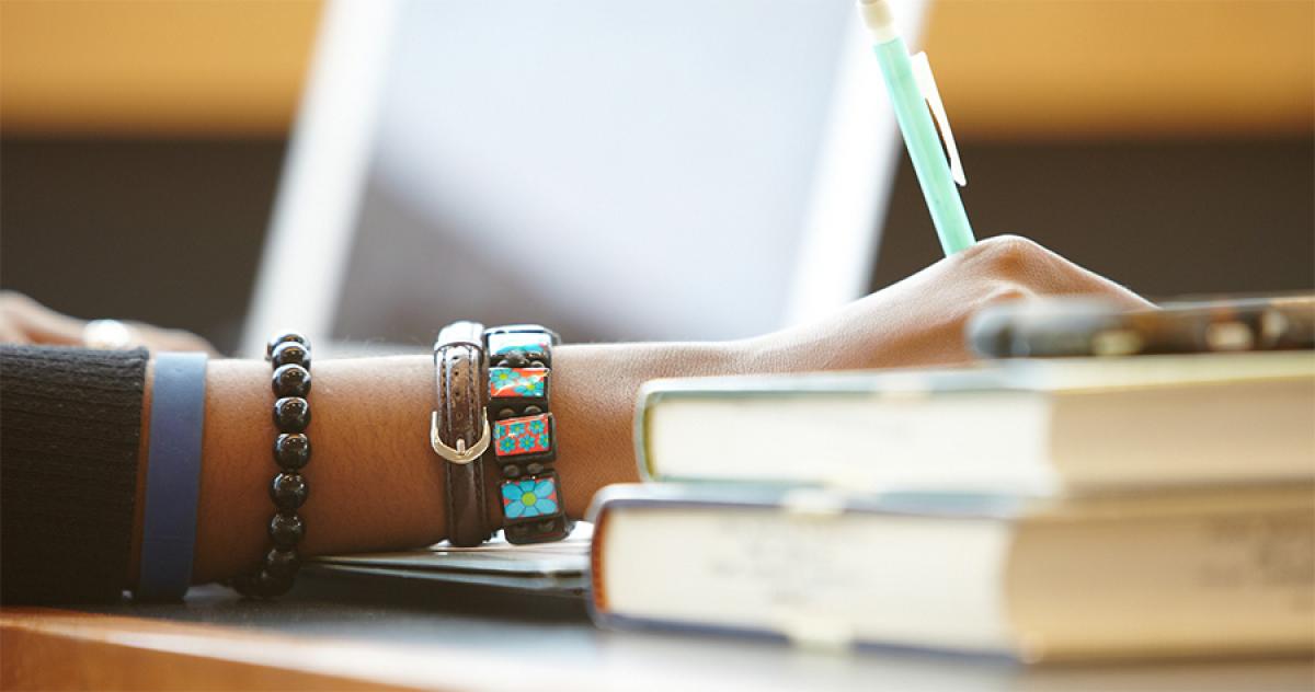 Admissions Resources at Minneapolis College Hand on desk writing